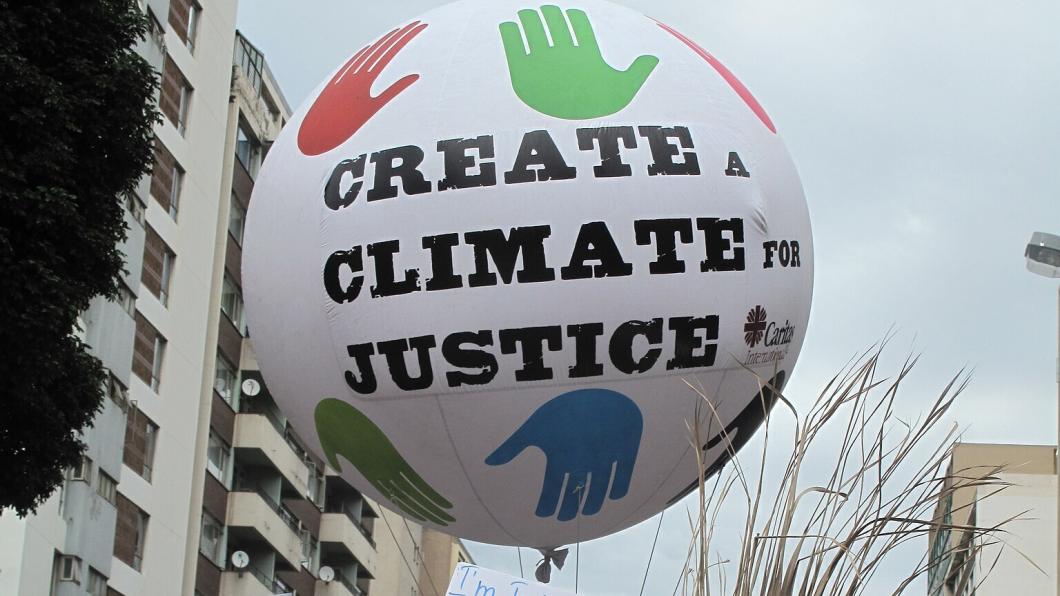 Demonstratie voor klimaatrechtvaardigheid met een ballon met daarop de tekst Create a climate for justice.