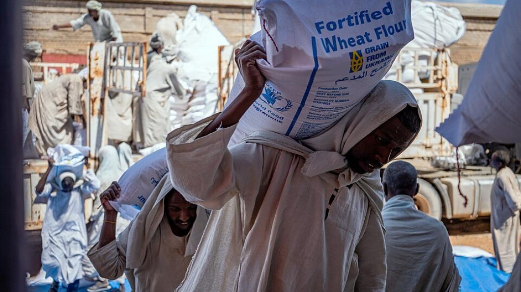 Mensen dragen zakken met graan uit Oekraïne.