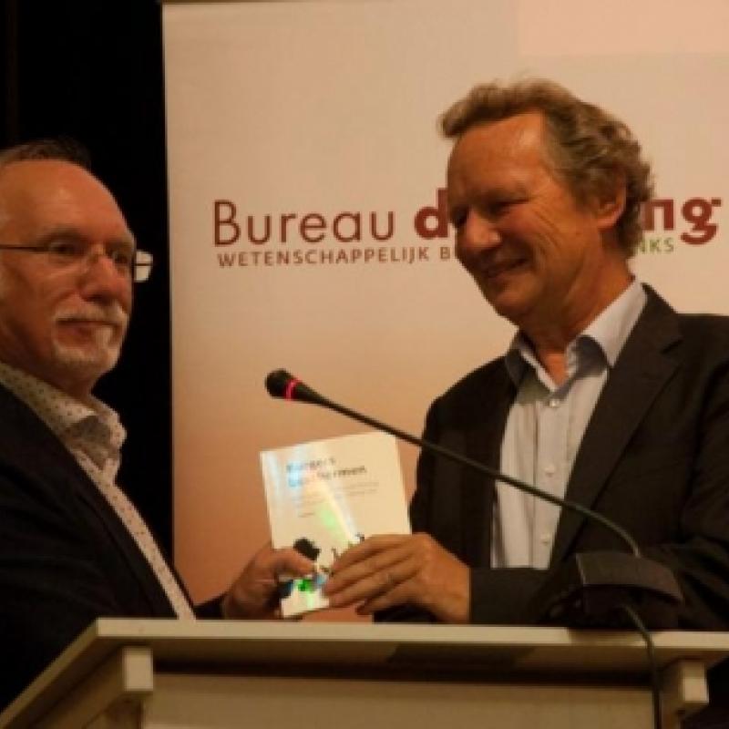 Bram van Ojik neemt de publicatie 'Burgers beschermen. GroenLinks van Koude Oorlog naar humanitaire interventie' in ontvangst van auteur Gerrit Pas.
