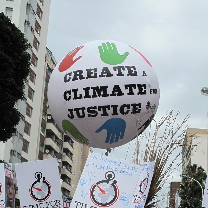 Demonstratie voor klimaatrechtvaardigheid met een ballon met daarop de tekst Create a climate for justice.