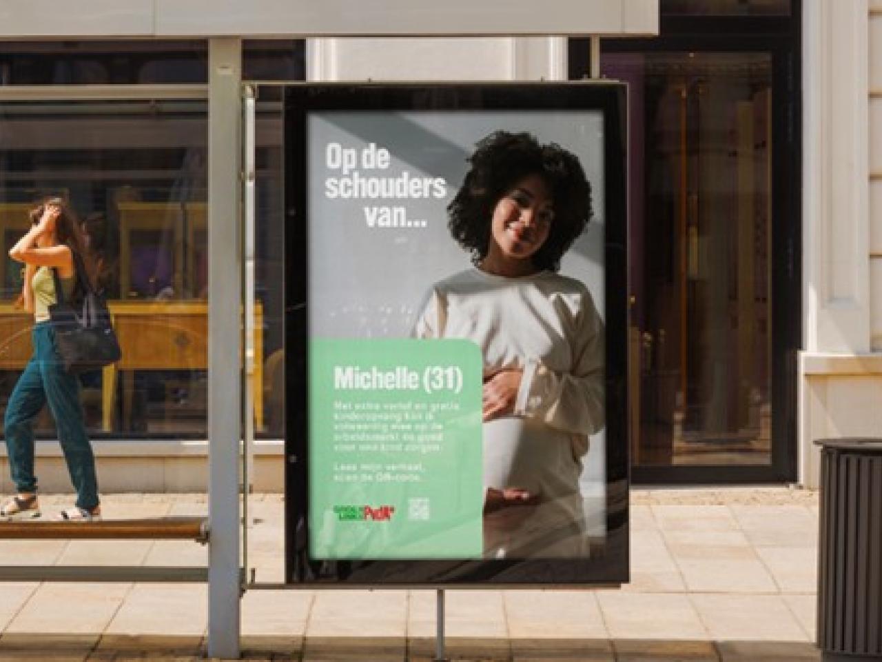 Affiche op straat voor campagne 'Op de schouders van' met zwangere vrouw